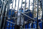 A hooded student guards his high school after student protesters took over the campus during a march on Aug. 28. The hooded protesters, known as encapuchados, stacked chairs from their classrooms against the school’s front gates. To enter a campus and break up a takeover, police need a warrant, which can take up to two weeks to secure.