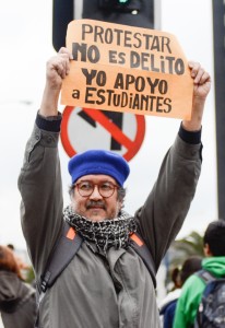 A protester holds a sign that reads, “Protesting is not a crime. I support the students.” Protesters often bring homemade signs to marches.