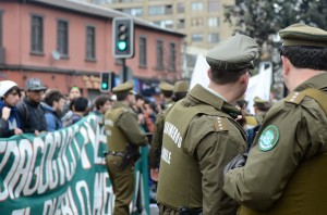 The carabineros, or Chilean police, look on as students chant at the end of a march on Aug. 28. At most marches in Santiago, Chile, protesters follow predetermined routes that range from three to five miles in length before gathering in public squares or plazas.