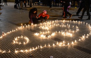 A mother and daughter light candles during a vigil at the University of Chile. The candles were laid out in the image of Manuel Gutiérrez, a high school student who died during a protest. 