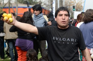 A street vendor sells lemons on the sidewalk during a march. Police often break up marches with tear gas, which causes a stinging sensation in the eyes and throat – protesters suck on lemons for relief.