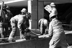 Firefighters help clear out piles of debris.