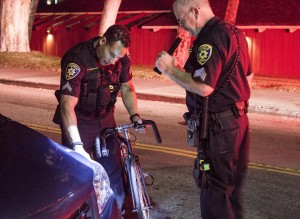 Sgt. Richard Francis helps another officer inspect a crash scene. (Carolyn Davis/Daily Bruin).