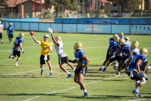 Freshman quarterback Josh Rosen delivers a pass as sophomore linebacker Kenny Young charges on a blitz. (Jose Ubeda/Daily Bruin staff)